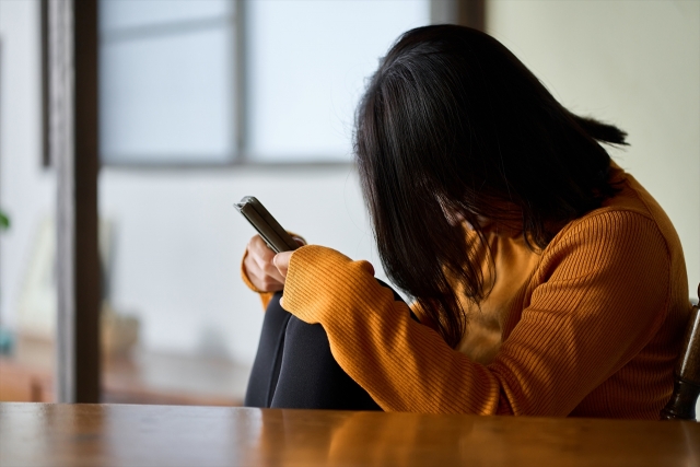 スマホを見て落ち込む人